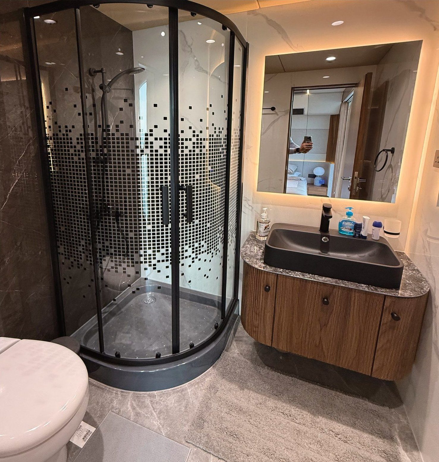 Head with glass shower enclosure, stone basin and walnut joinery