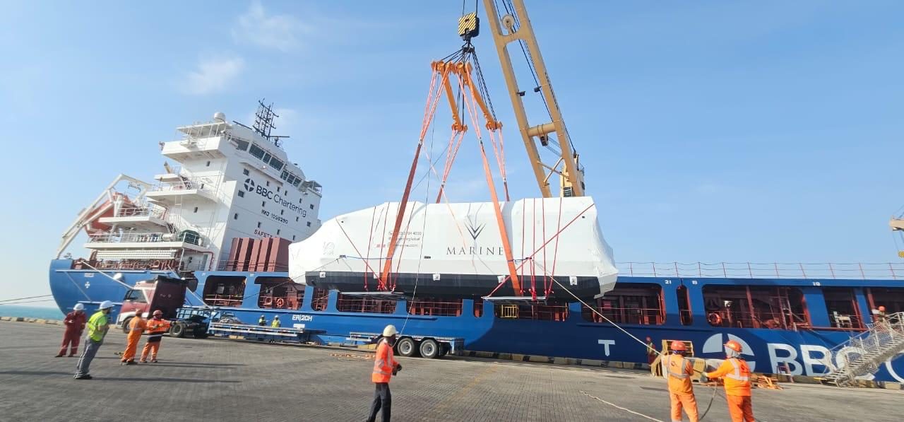 A wrapped V-Marine hull craned aboard a cargo ship at the port